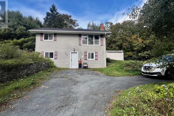 Split-level house exterior with grey siding, maroon shutters, and a dark asphalt driveway with a white SUV. - 2925 No. 7 Hwy, Lake Echo