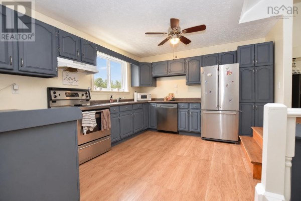 Kitchen with grey cabinets, stainless steel appliances, and wood laminate flooring. - 2925 No. 7 Hwy, Lake Echo