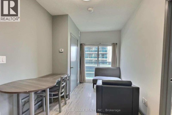 Small living area with a grey oval table, two chairs, and a sofa. - 293 - 258b Sunview Street, Waterloo