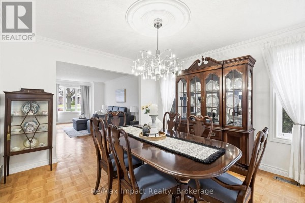 Aerial view of a tree-lined street with houses and a tennis court surrounded by greenery. - 293 Blue Heron Drive, Oshawa