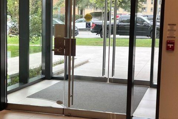 Double glass doors with metal handles leading into the building lobby. - 293 The Kingsway, Toronto