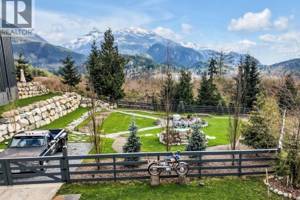 Panoramic view of snow-capped mountains and evergreen forest under a blue sky. - 2934 Huckleberry Drive, Squamish