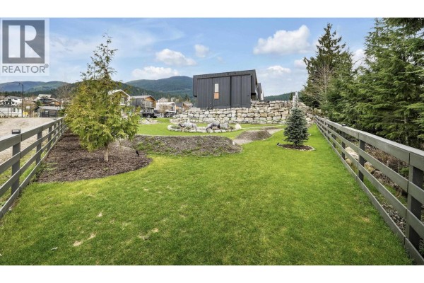 Aerial view of a triangular lot with a winding pathway, fire pit, and landscaping. - 2934 Huckleberry Drive, Squamish