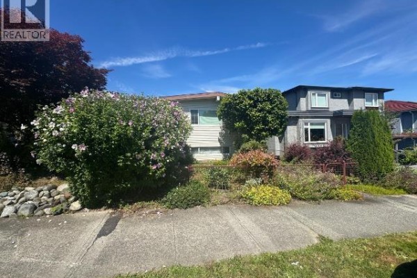 Side exterior view of the house at 2935 Adanac Street, adjacent to a two-story building. - 2935 Adanac Street, Vancouver