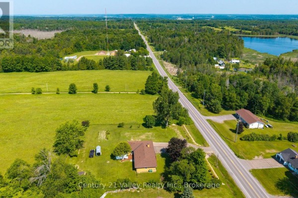 Aerial view of properties along a rural road surrounded by fields and forests. - 2935 Burnstown Road, Horton