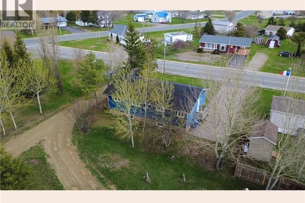 Side view of blue house with snow, showing yard and adjacent properties - 2938 Rue Chiasson, Bas Caraquet