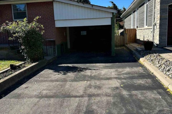 Asphalt driveway leading to a carport with surrounding landscaping and neighboring homes. - 294 Felan Avenue, Oakville