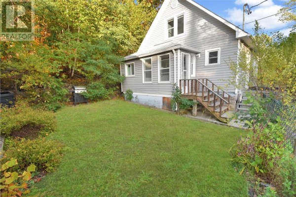 View of the house and grassy backyard from the side. - 294 Kathleen Street, Sudbury