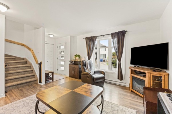 Living room with a recliner, television, coffee table, and a view of the front street through the window. - 294 Rue Des Becs-scie, Gatineau