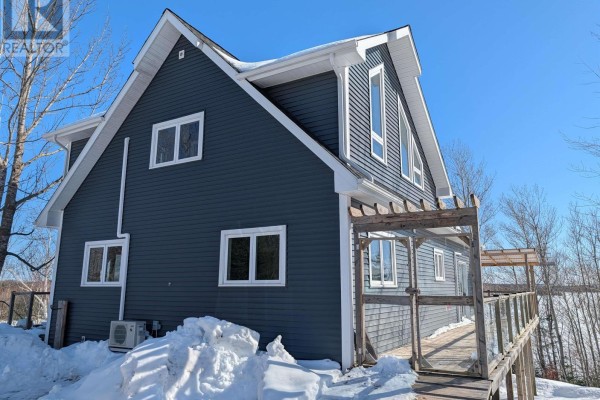 Side view of the house showing the deck and snowy landscape. - 294 Terra Tory Dr, Lanark