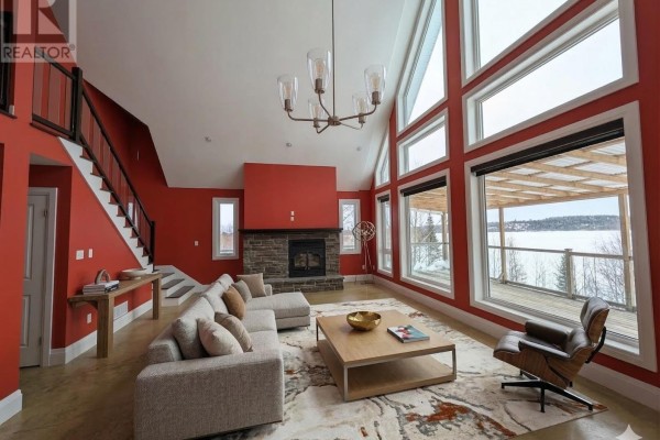 Interior loft area with large windows and a modern railing. - 294 Terra Tory Dr, Lanark