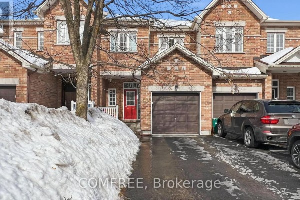 Townhouse facade featuring brickwork, snowbank, and parked vehicles - 294 Waymark Crescent, Ottawa