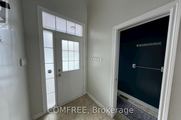 Entryway with glass-paneled door, tile flooring, and coat hooks - 294 Waymark Crescent, Ottawa