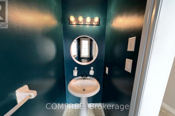Powder room with dark teal walls, round mirror, and pedestal sink - 294 Waymark Crescent, Ottawa
