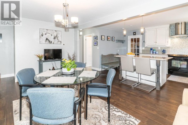 Kitchen with white cabinetry, a central island, stainless steel appliances, and a glass door. - 295 Bishop Street, Gravenhurst)