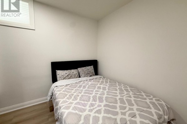 Small bedroom with a bed, patterned bedding, and a window with horizontal blinds. - 2954 Elgin Mills Road E, Markham