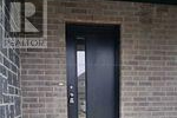 Close-up of the dark grey front door with a glass insert and silver hardware. - 2954 Turner Crescent, London South