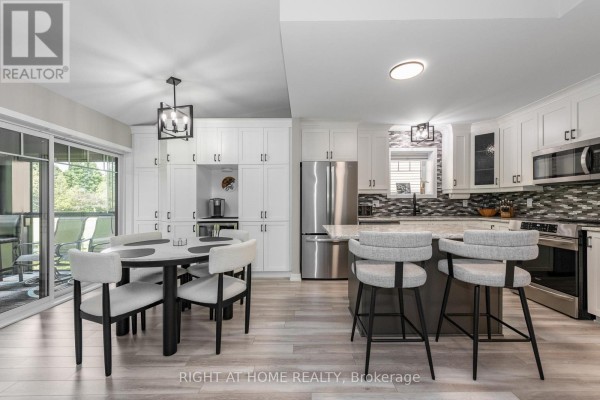 Open-concept kitchen and dining area with a large island, table, chairs, and patio access. - 296 - 308 Masters Lane, Clarence Rockland