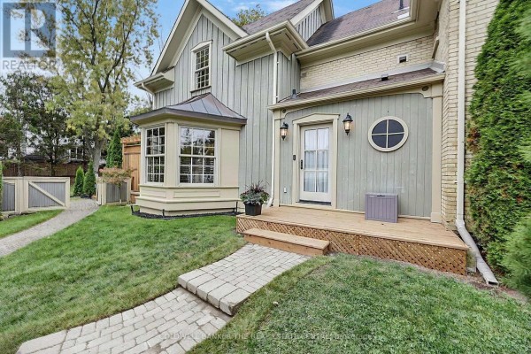 Close-up view of the house exterior with a deck, bay window, and stone pathways. - 296 Eagle Street, Newmarket