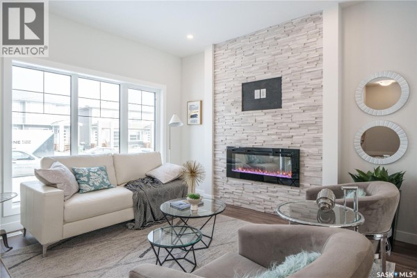 Kitchen with white cabinets, grey tile backsplash, and stainless steel microwave, facing the island. - 2972 Green Turtle Road, Regina