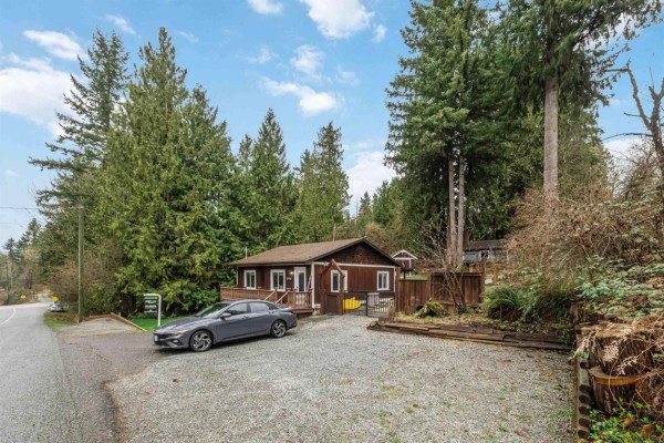 Side view of the house with gravel parking area and nearby trees. - 29791 Silverdale Avenue, Mission