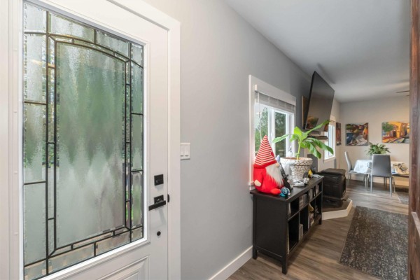 Entryway with decorative glass door, leading to a living area with a TV and dining space. - 29791 Silverdale Avenue, Mission