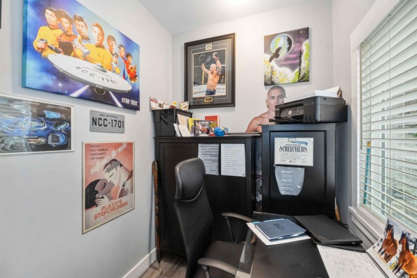Small home office with posters, black filing cabinet, and desk, featuring natural light from a window. - 29791 Silverdale Avenue, Mission