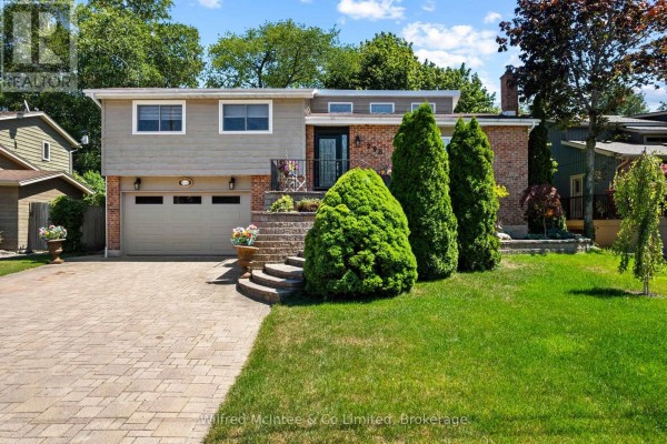 Rear patio with stone pavers, outdoor furniture, and umbrellas. - 298 Albert Street S, Saugeen Shores