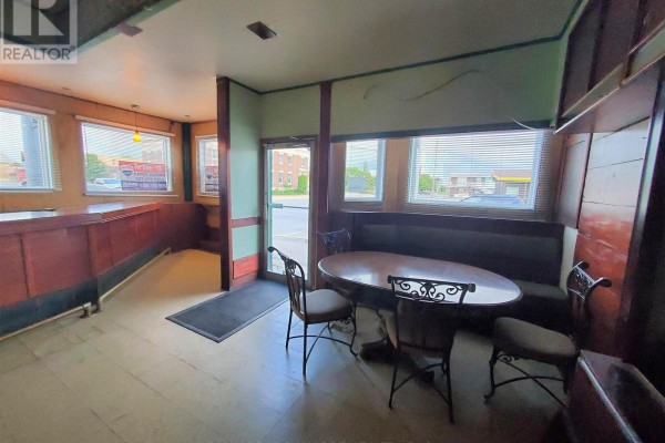 Interior view of a room with a pool table, green walls, and wooden accents. - 298 Scott Street, Fort Frances