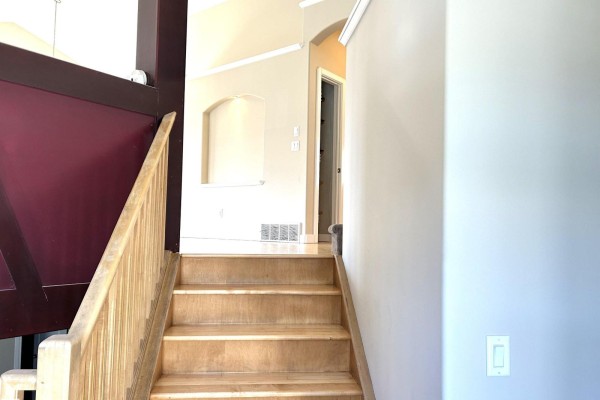 Interior view of a staircase with wood railings and a loft area above. - 2984 Mcphadden Wy Sw, Edmonton