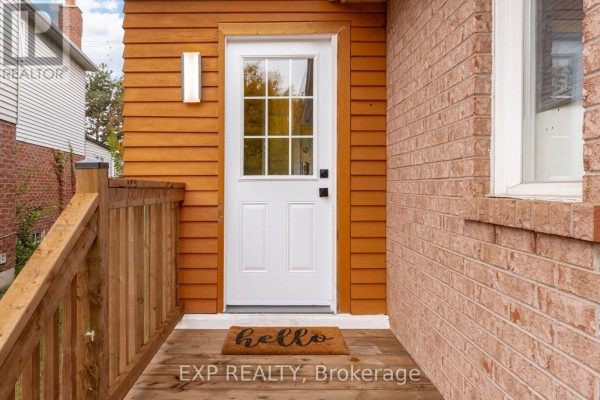 Wooden porch with a white front door and a 'hello' doormat. - 2993 Gulfstream Way, Mississauga