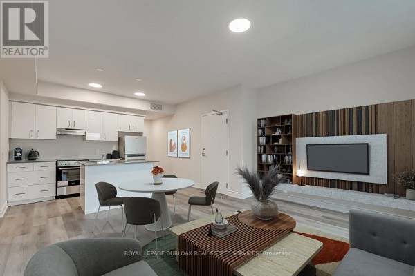 Open concept living and kitchen area with white cabinets and a dining table. - 2a - 259 King Street E, Hamilton