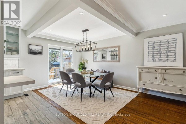 Dining room with a glass table, grey chairs, a white buffet, and a sliding glass door. - 2a Elton Crescent, Toronto