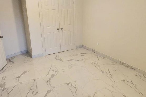 Bedroom with double closet doors and view of tiled floor. - 2b-3rd Floor - 1030 St Clair Avenue, Toronto