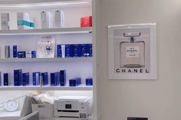 Shelves stocked with skincare products and a framed Chanel No. 5 advertisement. - 2n - 26 Bellair Street, Toronto