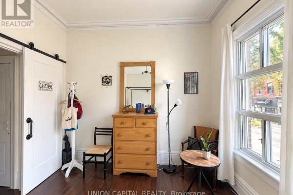 Bedroom with a dresser, chair, sliding barn door, and window. - 2nd Fl - 459 Queen Street W, Toronto