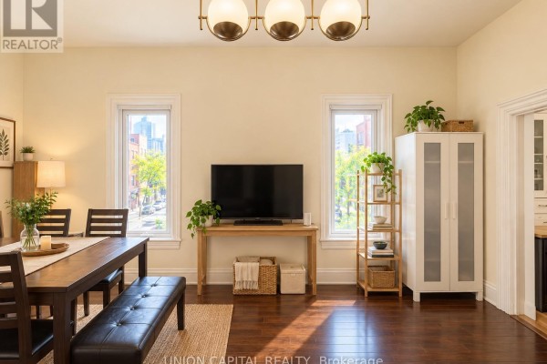 Living and dining area with a TV, dining table, bench, and cabinets. - 2nd Fl - 459 Queen Street W, Toronto