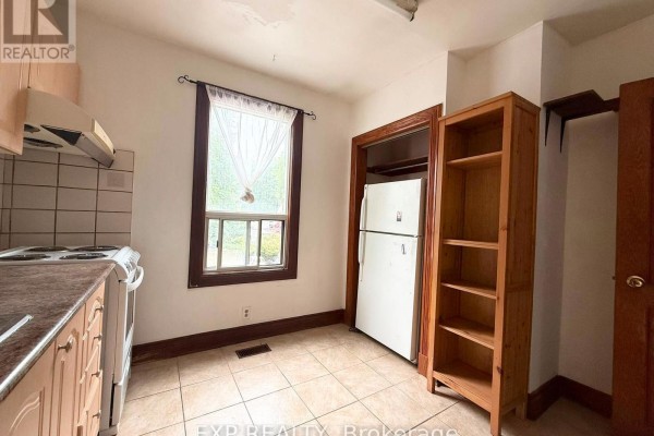 Kitchen with light wood cabinets, refrigerator, and wooden shelving unit beside a window. - 2nd Fl - 759 Gerrard Street E, Toronto