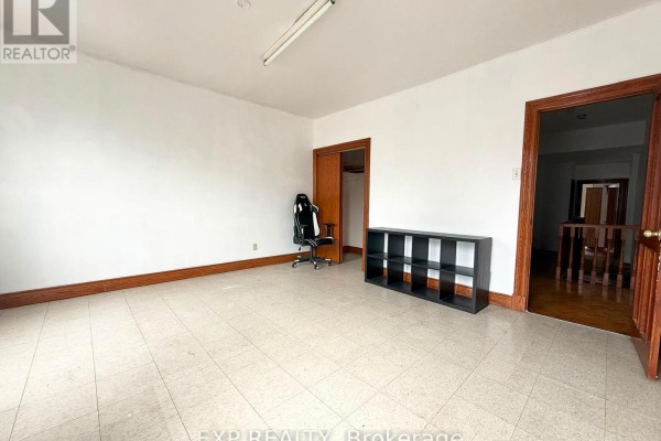 Room with white walls, tiled floor, black shelving unit, and office chair. - 2nd Fl - 759 Gerrard Street E, Toronto