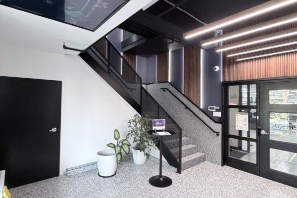 Interior entrance with a staircase, black doors, and vertical wood paneling. - 2nd Floor - 139 Mulock Avenue, Toronto