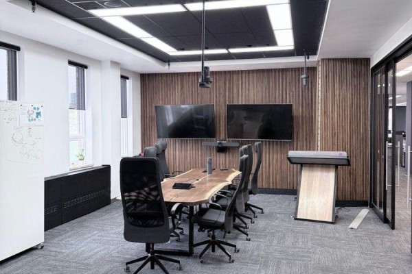 Modern boardroom with a long wooden table, black chairs, and two large screens. - 2nd Floor - 139 Mulock Avenue, Toronto