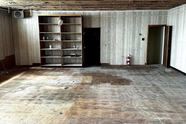 Room with wood-paneled walls, a large bookshelf, and a fire extinguisher next to a doorway. - 2nd Floor - 257 Front Street, Belleville