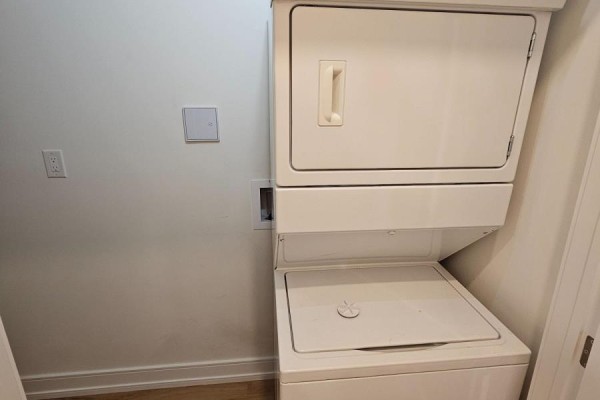 Stacked white washer and dryer unit in a small closet space. - 2nd Floor - 3293 Dundas Street W, Toronto