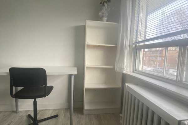 White desk, chair, and bookshelf against a white wall next to a window with blinds. - 2nd Floor Room - 2518 Lake Shore Boulevard, Toronto
