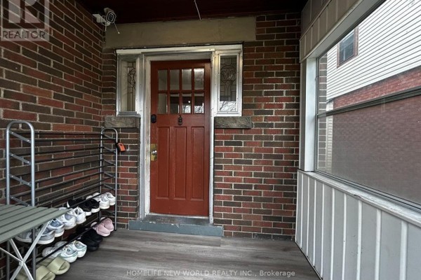 Covered front porch with a red door, brick walls, and a shoe rack. - 2nd Rm 3 - 46 Arnold Street, Hamilton
