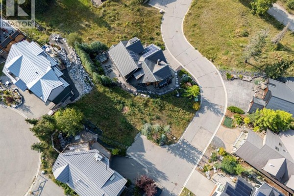 Overhead view of a sloped lot with surrounding houses featuring metal roofs and balconies. - 3, 126 Benchlands Terrace, Canmore