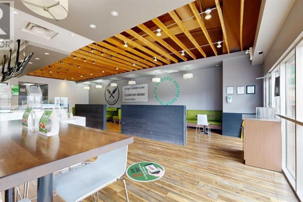 Restaurant seating area with wood-paneled walls, counter seating, and menu boards above service counter. - 3, 4706 50 Street, Stettler