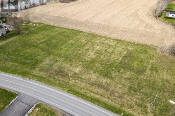 View of open land with road and utility poles, adjacent to farmland. - 3 - 0000 Lakeshore Drive, South Dundas