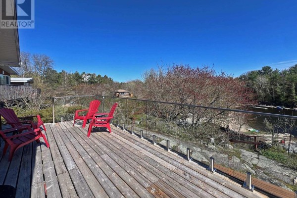 Gym room with cardio equipment, large windows overlooking a lake, and wood paneled walls. - 3 - 111 North Shore Road, The Archipelago