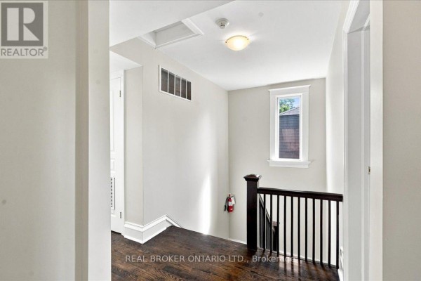Empty room with dark hardwood floors and a large window. - 3 - 12 Foxbar Road, Toronto